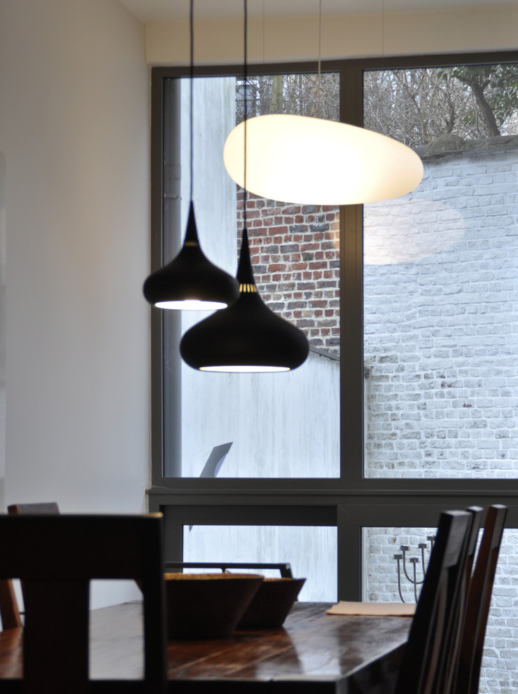 This is an example of an eclectic dining room in Brussels with grey walls and light hardwood floors.