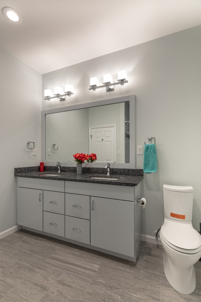 Photo of a large transitional kids bathroom in DC Metro with flat-panel cabinets, black cabinets, an alcove shower, a one-piece toilet, gray tile, purple walls, light hardwood floors, an undermount sink, engineered quartz benchtops, beige floor, a sliding shower screen, grey benchtops, a shower seat, a double vanity and a built-in vanity.