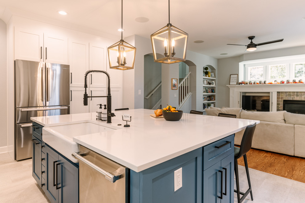 Design ideas for a large country l-shaped open plan kitchen in Denver with a single-bowl sink, shaker cabinets, blue cabinets, quartzite benchtops, white splashback, ceramic splashback, stainless steel appliances, vinyl floors, with island, beige floor and white benchtop.