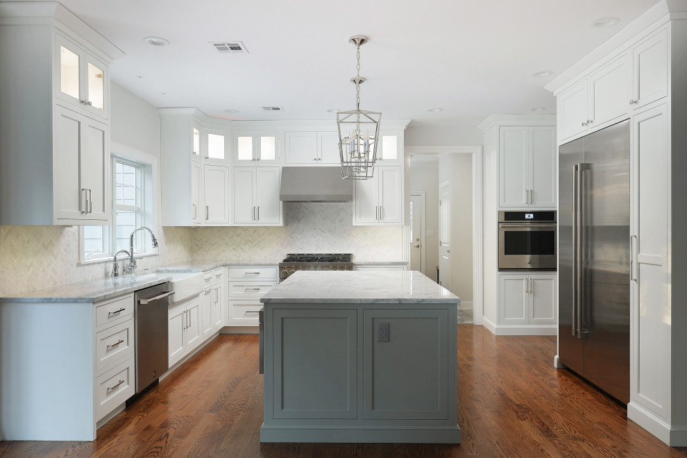 Example of a large transitional u-shaped medium tone wood floor eat-in kitchen design with shaker cabinets, white cabinets, stainless steel appliances and an island