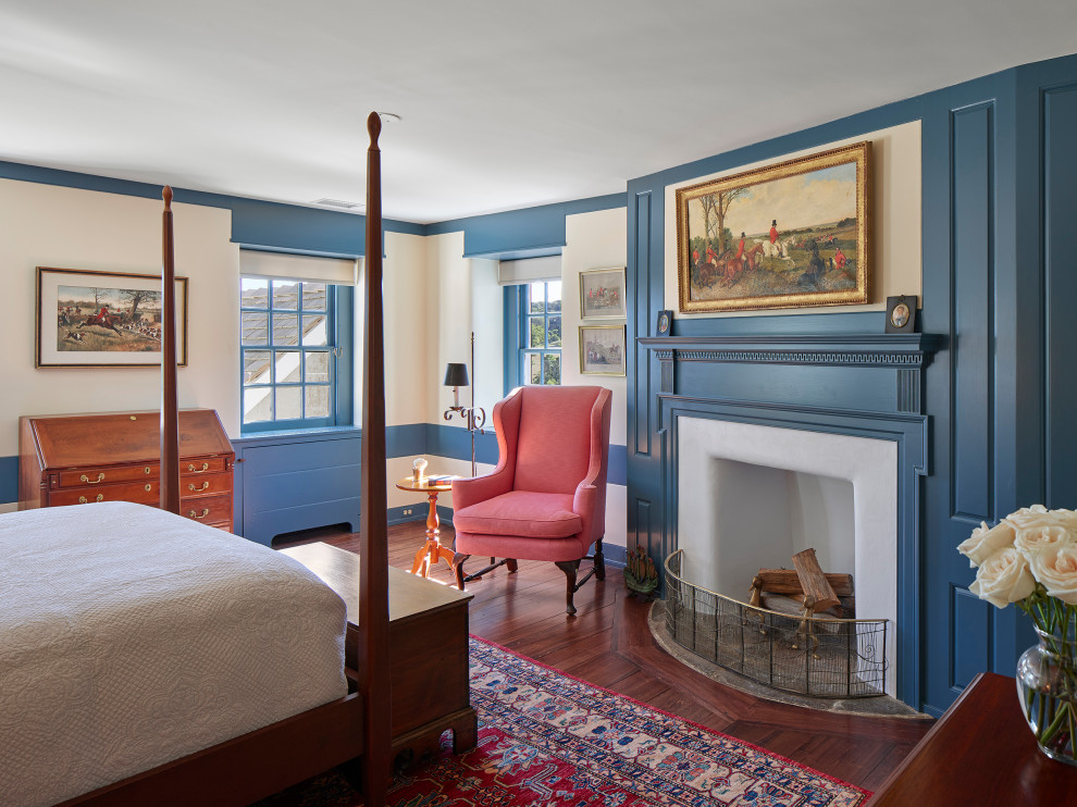 Foto de habitación de invitados tradicional con paredes azules, suelo de madera en tonos medios, todas las chimeneas y marco de chimenea de madera