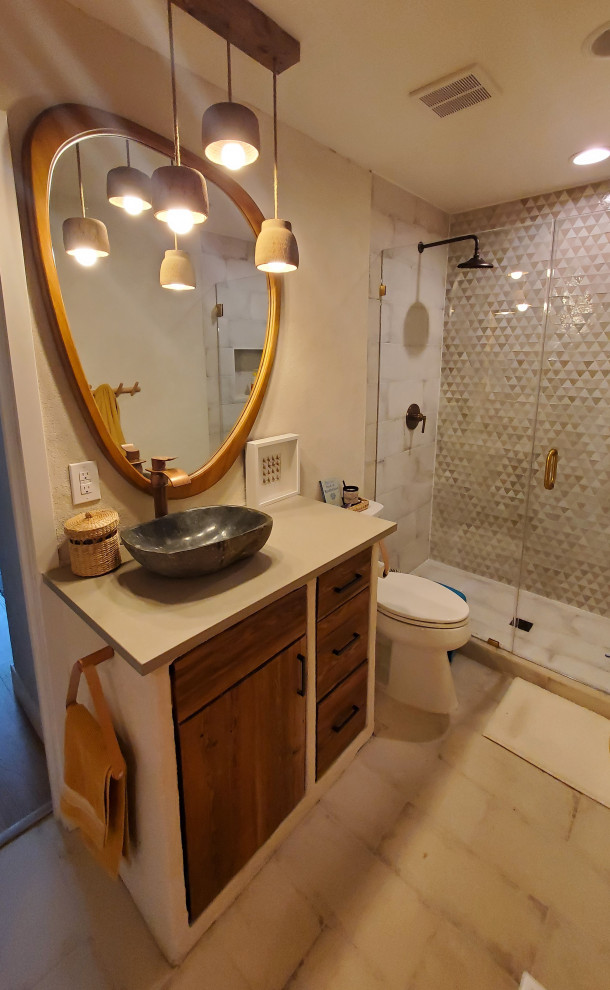 Photo of a medium sized mediterranean family bathroom in Denver with flat-panel cabinets, dark wood cabinets, an alcove shower, a two-piece toilet, beige tiles, stone tiles, beige walls, porcelain flooring, a vessel sink, engineered stone worktops, beige floors, a hinged door, grey worktops, a single sink and a built in vanity unit.