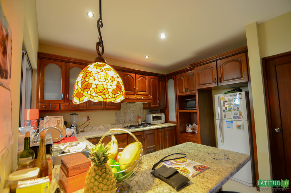 Home design - small rustic u-shaped porcelain tile home design idea with a drop-in sink, light wood cabinets, granite countertops, beige backsplash, white appliances, recessed-panel cabinets, stone slab backsplash and a peninsula