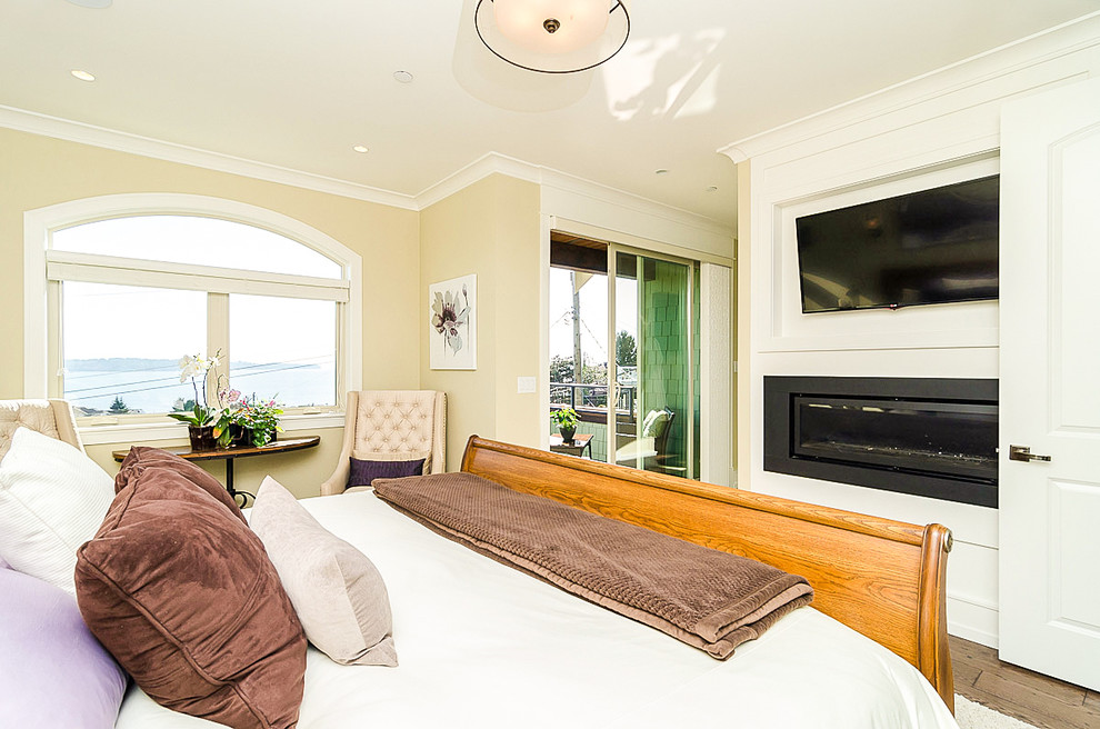 Photo of a mid-sized arts and crafts master bedroom in Vancouver with beige walls, a ribbon fireplace and a metal fireplace surround.