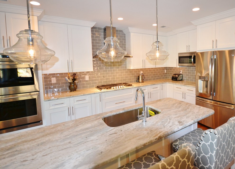 Large traditional single-wall eat-in kitchen in Philadelphia with an undermount sink, raised-panel cabinets, white cabinets, granite benchtops, brown splashback, subway tile splashback, stainless steel appliances, medium hardwood floors and with island.