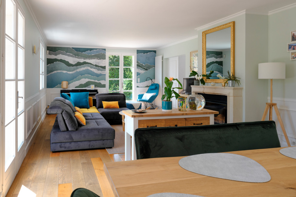 Exemple d'une salle à manger bord de mer de taille moyenne avec une banquette d'angle, un mur vert, parquet clair, une cheminée standard, un manteau de cheminée en pierre, un sol jaune et du papier peint.
