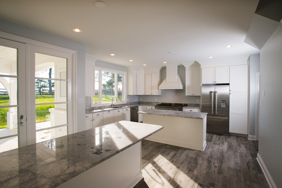 Eat-in kitchen - mid-sized transitional u-shaped light wood floor eat-in kitchen idea with a double-bowl sink, raised-panel cabinets, white cabinets, soapstone countertops, gray backsplash, stainless steel appliances and an island
