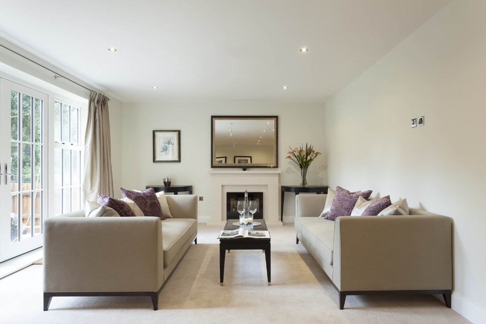 This is an example of a transitional formal living room in London with white walls, carpet and a standard fireplace.