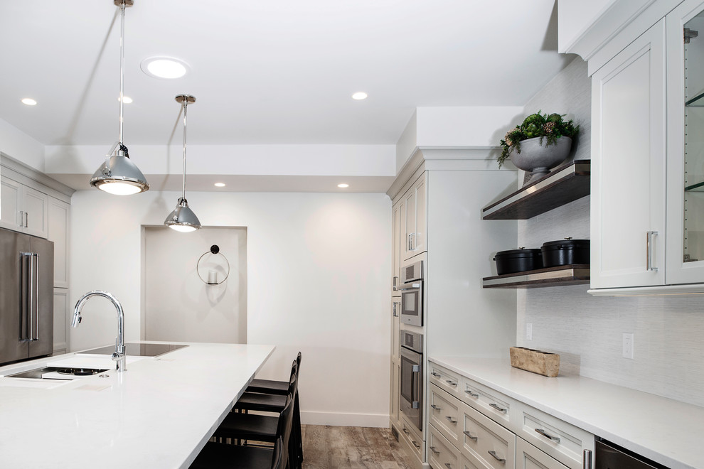 Inspiration for a mid-sized transitional single-wall vinyl floor and brown floor eat-in kitchen remodel with an undermount sink, quartzite countertops, white backsplash, stainless steel appliances, an island, shaker cabinets, gray cabinets and porcelain backsplash