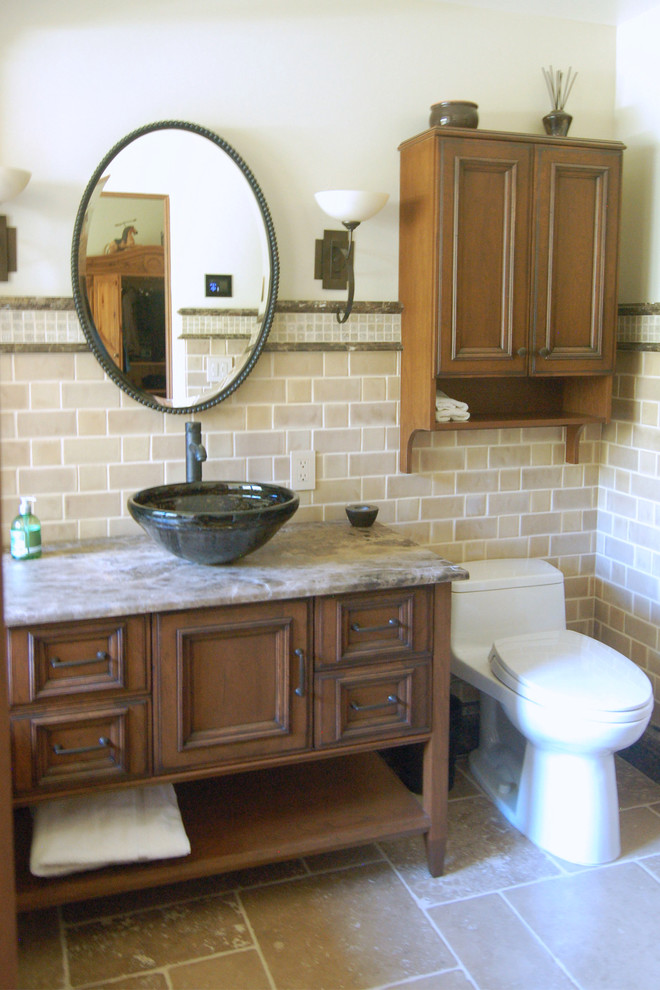 Mid-sized arts and crafts 3/4 bathroom in San Luis Obispo with a vessel sink, recessed-panel cabinets, distressed cabinets, onyx benchtops, a one-piece toilet, beige walls and travertine floors.