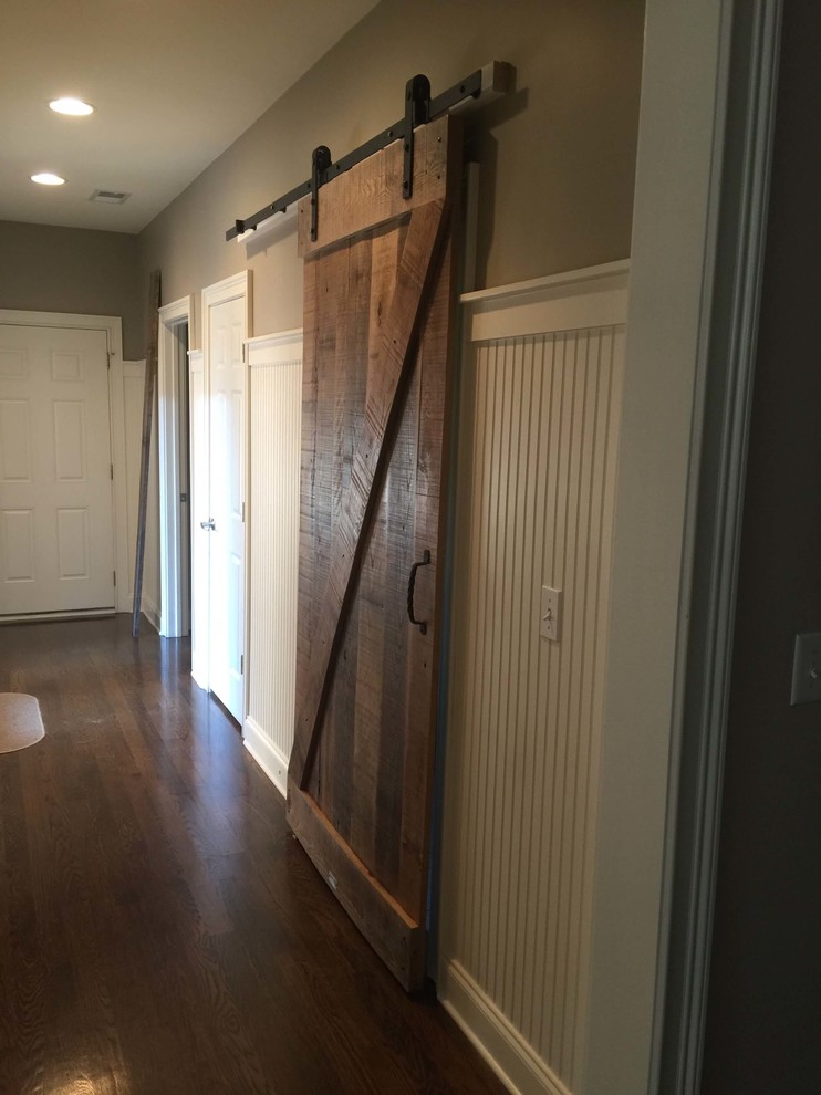 Photo of a large country hallway in Nashville with brown walls and dark hardwood floors.