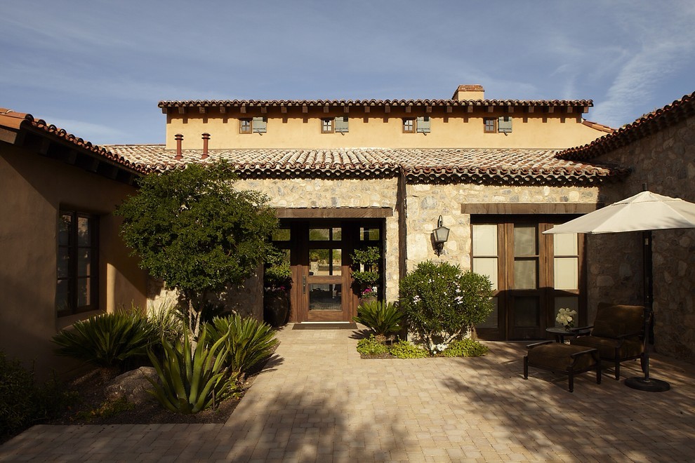 Photo of a large transitional split-level beige exterior in Phoenix with stone veneer.