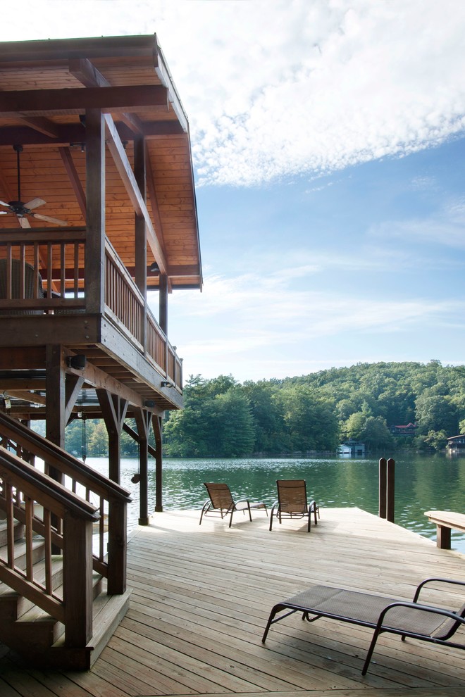 This is an example of a mid-sized traditional side yard deck in Other with with dock and a roof extension.