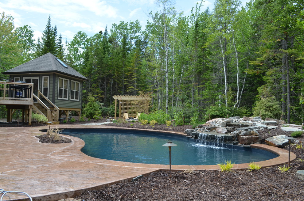 Inspiration for a large rustic backyard stamped concrete and custom-shaped natural pool remodel
