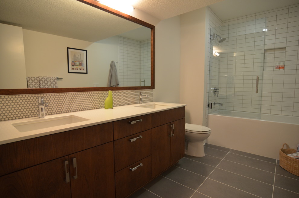 Mid-sized modern 3/4 bathroom in Portland with an undermount sink, flat-panel cabinets, medium wood cabinets, engineered quartz benchtops, a shower/bathtub combo, white tile, ceramic tile, white walls and ceramic floors.