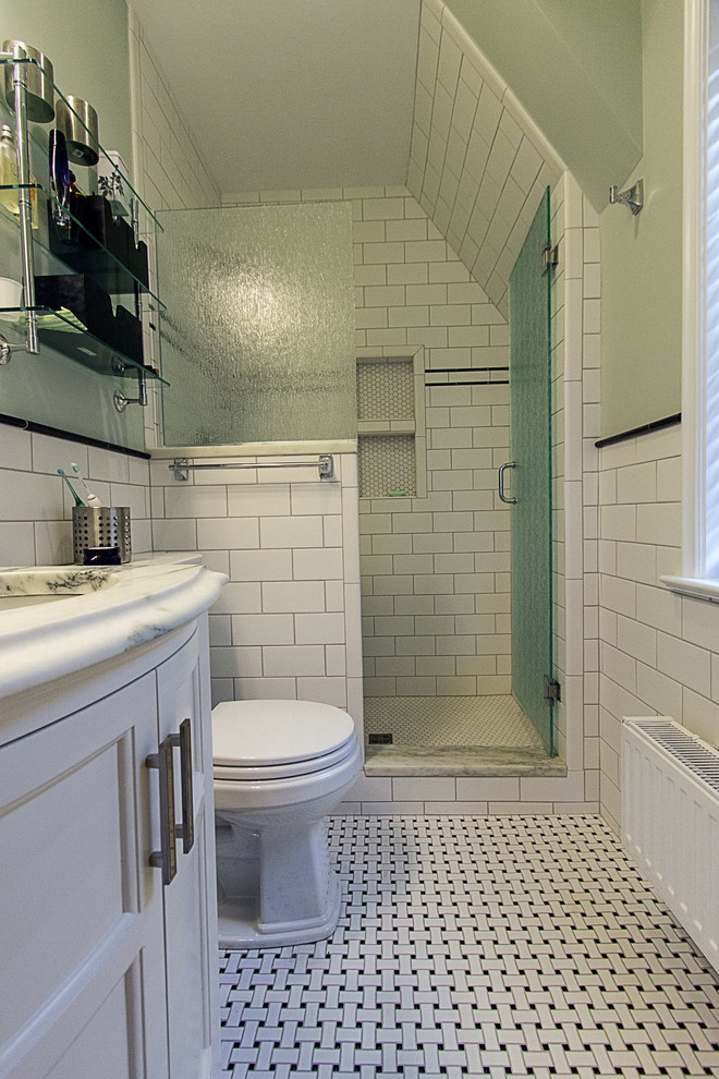 Photo of a mid-sized traditional master bathroom in Other with recessed-panel cabinets, white cabinets, an alcove shower, a two-piece toilet, black and white tile, ceramic tile, green walls, ceramic floors, an integrated sink, marble benchtops and white floor.