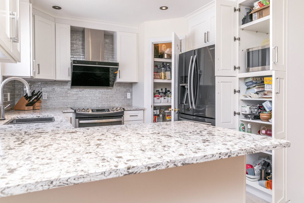 Small contemporary u-shaped eat-in kitchen in Montreal with a double-bowl sink, shaker cabinets, white cabinets, quartzite benchtops, grey splashback, cement tile splashback, stainless steel appliances, ceramic floors, with island, beige floor and multi-coloured benchtop.