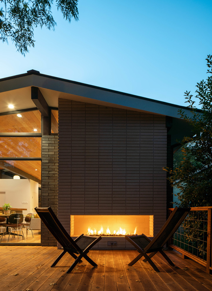 Inspiration for a large midcentury backyard deck in Dallas with with fireplace and no cover.