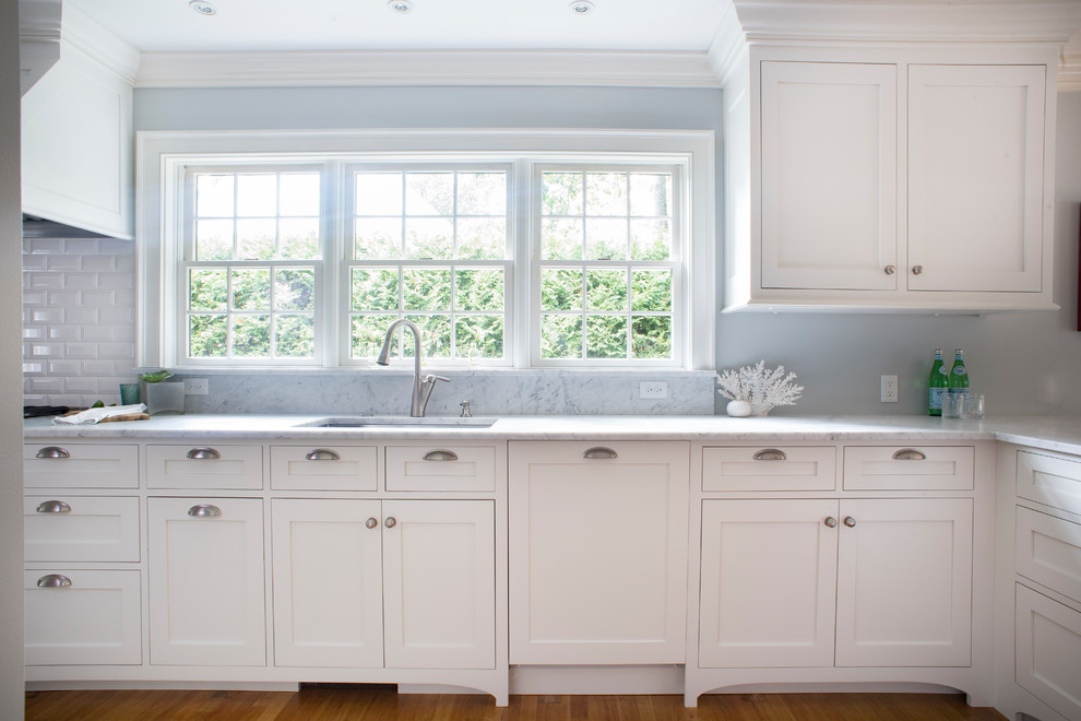 Design ideas for a mid-sized beach style galley eat-in kitchen in Portland Maine with an undermount sink, shaker cabinets, white cabinets, marble benchtops, white splashback, subway tile splashback, stainless steel appliances, medium hardwood floors, a peninsula and brown floor.