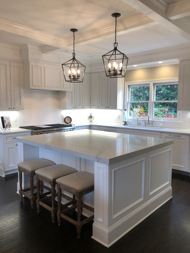 Inspiration for a large traditional u-shaped eat-in kitchen in Charlotte with an undermount sink, raised-panel cabinets, white cabinets, quartzite benchtops, white splashback, subway tile splashback, stainless steel appliances, dark hardwood floors, with island, black floor and white benchtop.