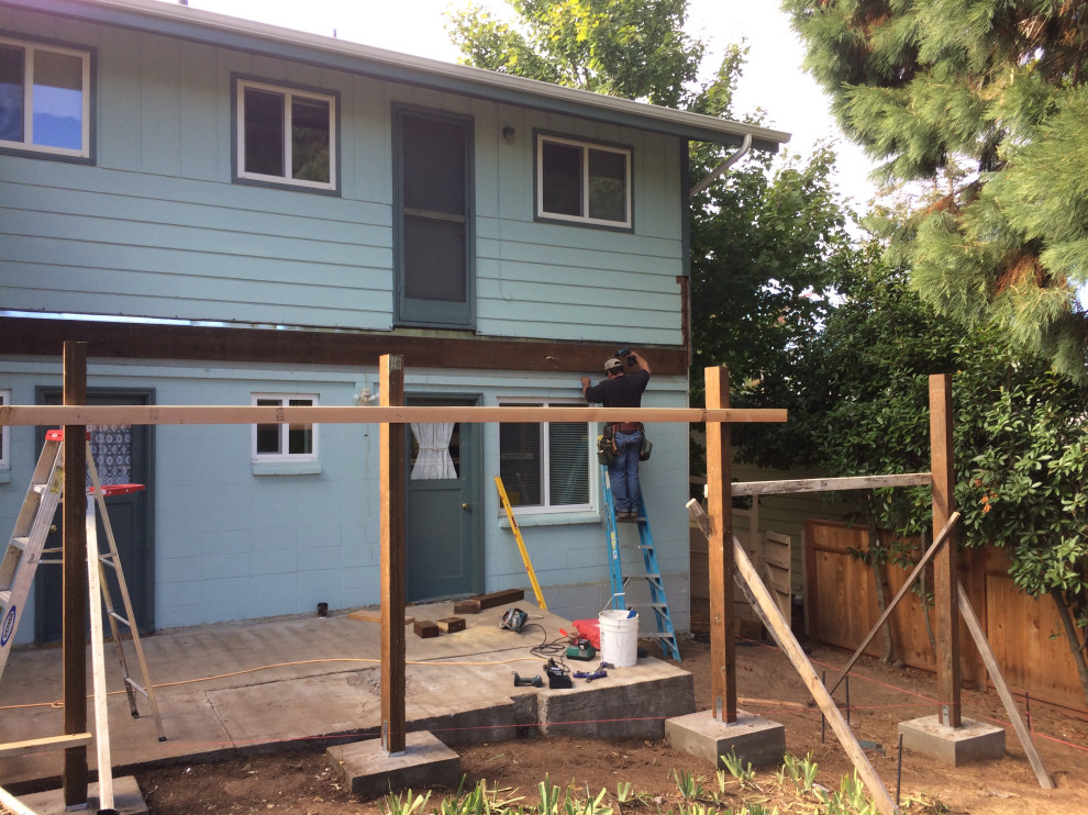 Example of a small backyard ground level wood railing deck design with no cover