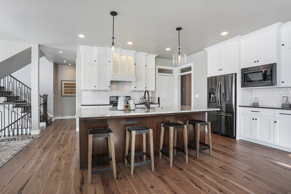 Inspiration for a large transitional l-shaped light wood floor and brown floor eat-in kitchen remodel with an undermount sink, shaker cabinets, white cabinets, quartzite countertops, white backsplash, mosaic tile backsplash, stainless steel appliances, an island and white countertops