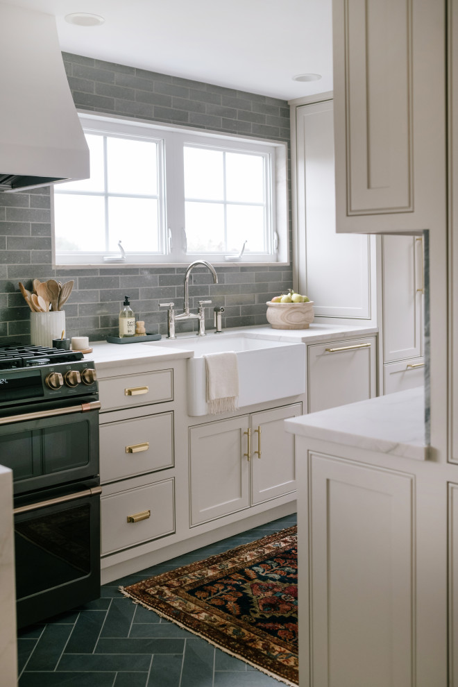 Photo of a small classic l-shaped kitchen/diner in Seattle with a belfast sink, beaded cabinets, grey cabinets, engineered stone countertops, green splashback, ceramic splashback, black appliances, porcelain flooring, a breakfast bar, grey floors and white worktops.