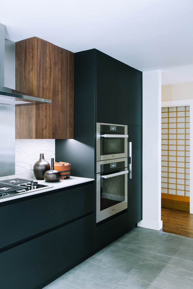 Design ideas for a mid-sized modern l-shaped eat-in kitchen in San Francisco with an undermount sink, flat-panel cabinets, black cabinets, grey splashback, stone tile splashback, stainless steel appliances, porcelain floors, a peninsula, grey floor and grey benchtop.