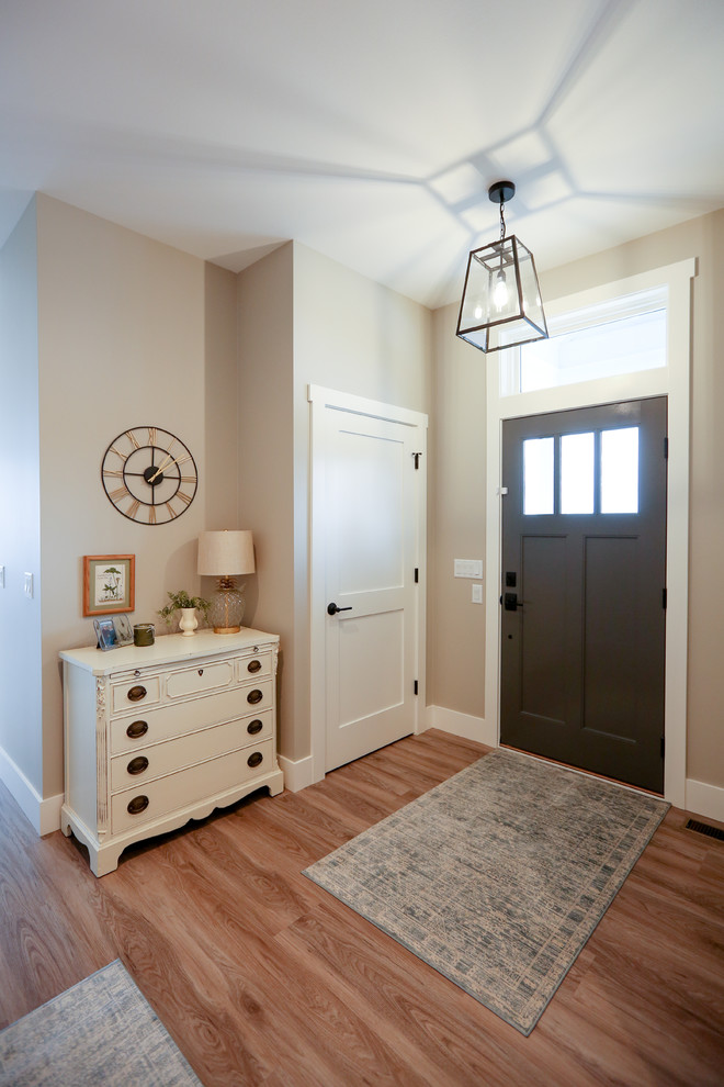 Front door - large transitional medium tone wood floor and brown floor front door idea with beige walls and a gray front door