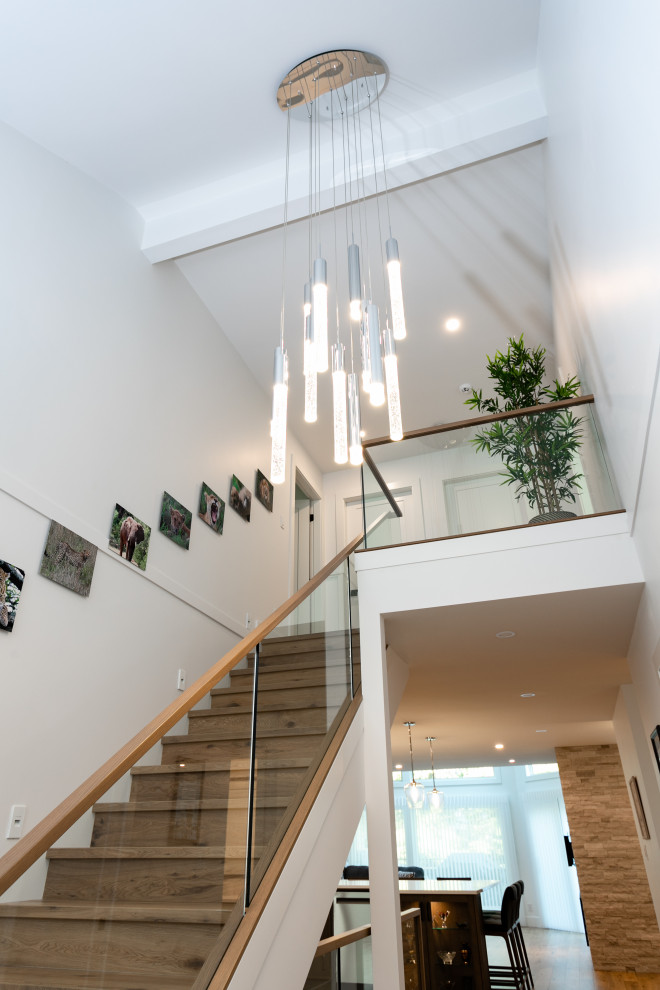 Inspiration for a medium sized traditional wood straight glass railing staircase in Vancouver with wood risers.