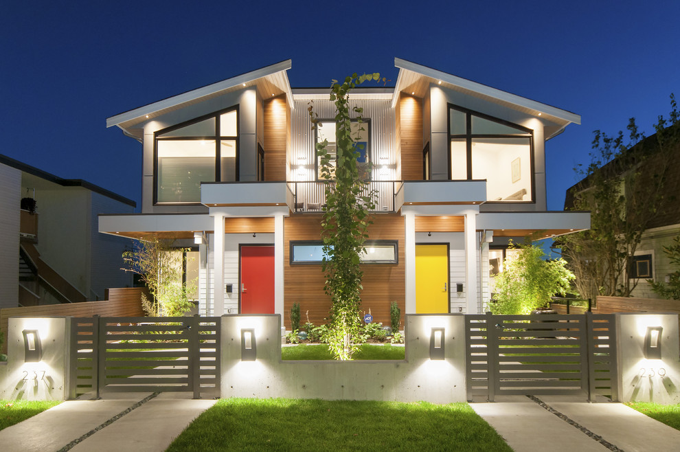 Photo of a mid-sized contemporary two-storey multi-coloured house exterior in Vancouver with mixed siding, a gable roof and a green roof.