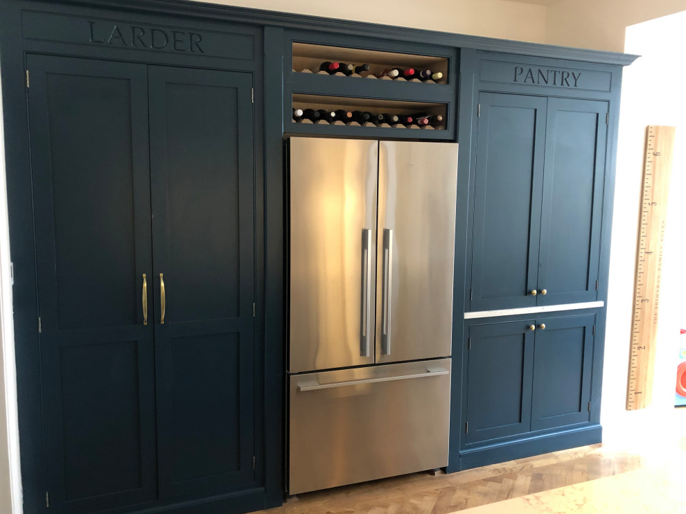 Inspiration for a mid-sized country single-wall eat-in kitchen in Surrey with beaded inset cabinets, blue cabinets, quartzite benchtops, stainless steel appliances, medium hardwood floors, with island and white benchtop.