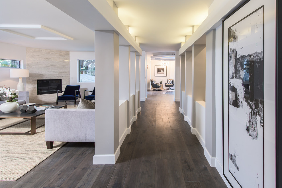 Photo of a large contemporary hallway in Los Angeles with grey walls, dark hardwood floors and brown floor.