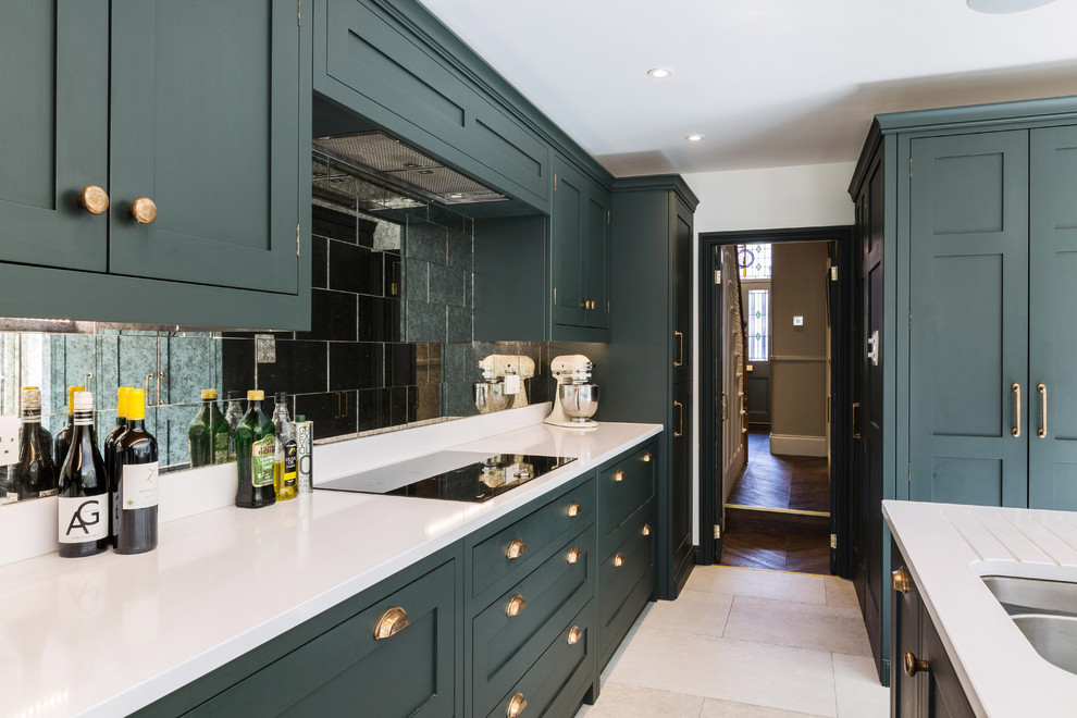 Design ideas for a large traditional l-shaped eat-in kitchen in London with an integrated sink, shaker cabinets, green cabinets, quartzite benchtops, metallic splashback, glass tile splashback, panelled appliances, limestone floors, with island, white floor and white benchtop.