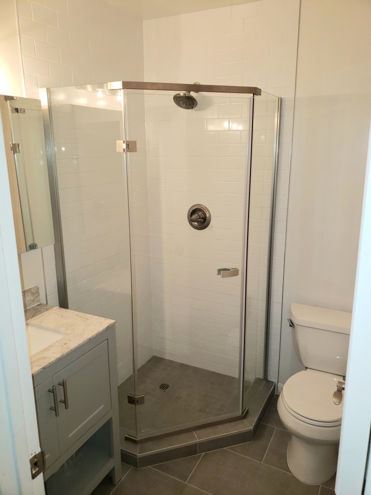 Design ideas for a small contemporary 3/4 bathroom in DC Metro with recessed-panel cabinets, grey cabinets, a corner shower, a two-piece toilet, white tile, subway tile, beige walls, porcelain floors, an undermount sink, quartzite benchtops, grey floor, a hinged shower door, a single vanity and a built-in vanity.