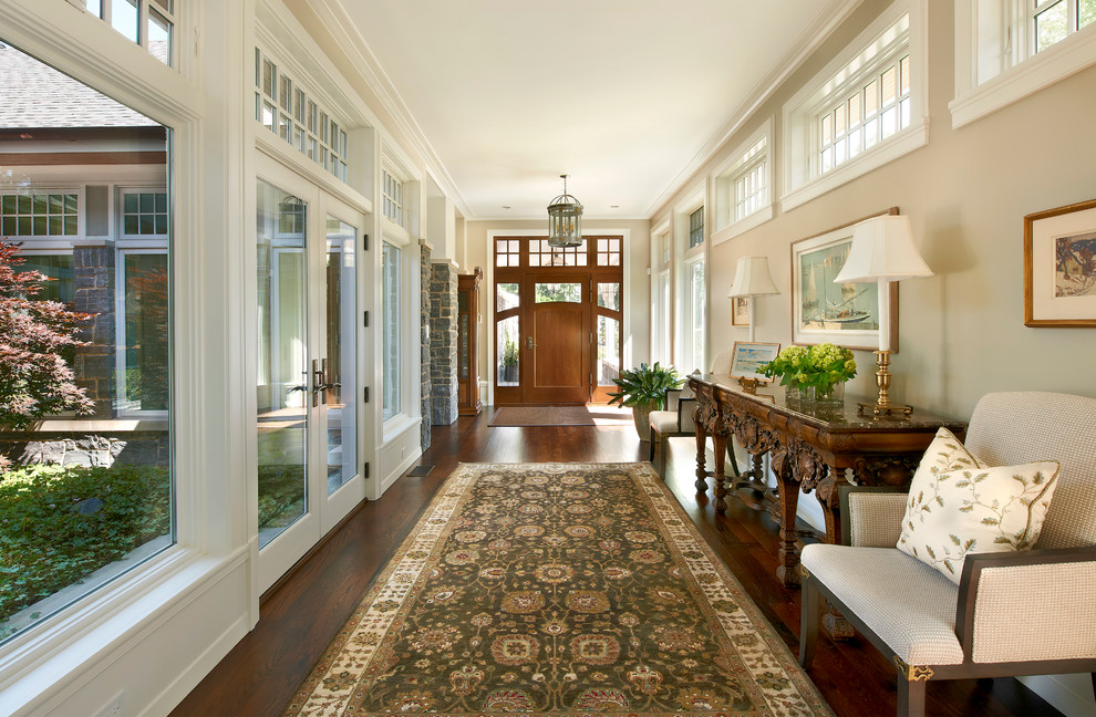This is an example of a mid-sized traditional foyer in Chicago with beige walls, dark hardwood floors, a single front door and a medium wood front door.