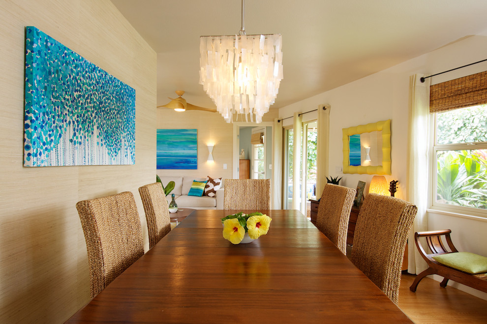 Photo of a mid-sized tropical dining room in Los Angeles with beige walls and medium hardwood floors.