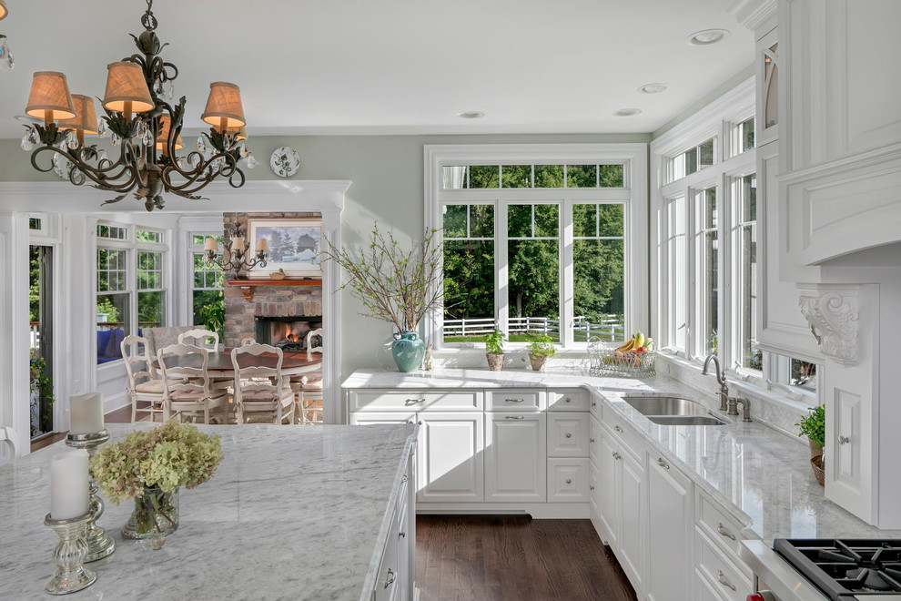 Photo of a large traditional separate kitchen in New York with raised-panel cabinets, white cabinets, marble benchtops, with island and white benchtop.