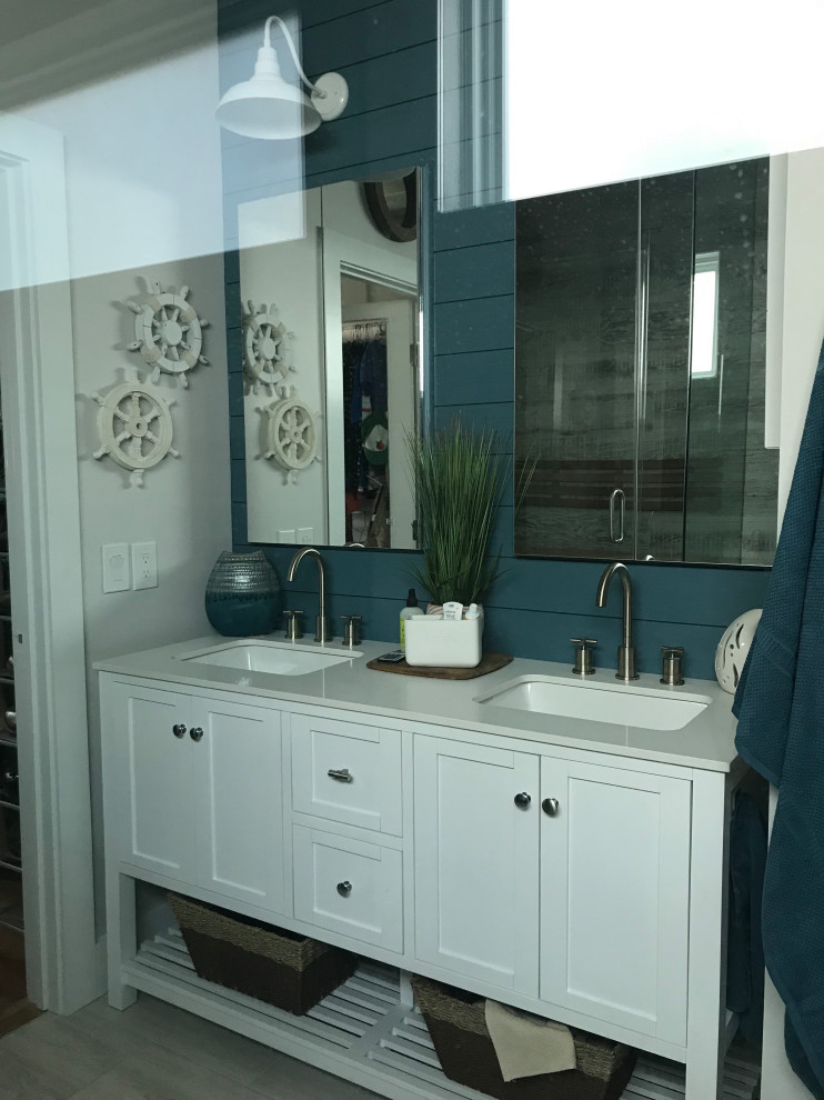 Design ideas for a large beach style master bathroom in Atlanta with beaded inset cabinets, white cabinets, a double shower, a two-piece toilet, beige tile, porcelain tile, blue walls, a drop-in sink, beige floor, a hinged shower door, a shower seat, a double vanity, a freestanding vanity and planked wall panelling.