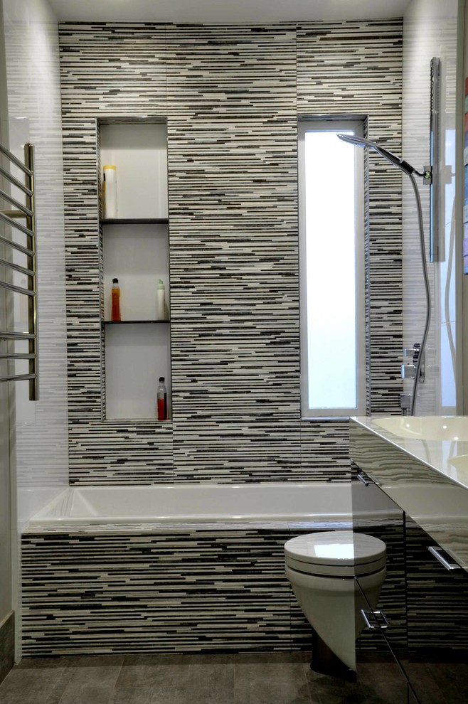 Inspiration for a small modern master bathroom in San Francisco with flat-panel cabinets, an alcove tub, a wall-mount toilet, multi-coloured tile, an integrated sink, brown floor and dark wood cabinets.