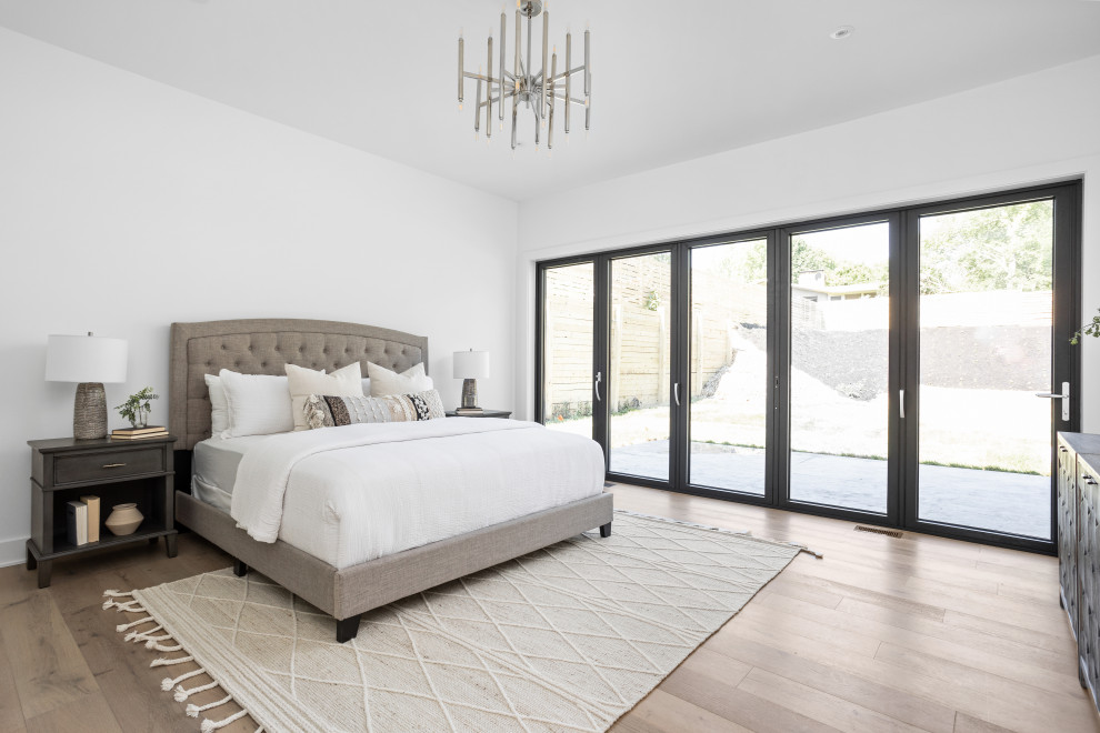 Inspiration pour une grande chambre parentale minimaliste avec un mur blanc, parquet clair et un sol multicolore.