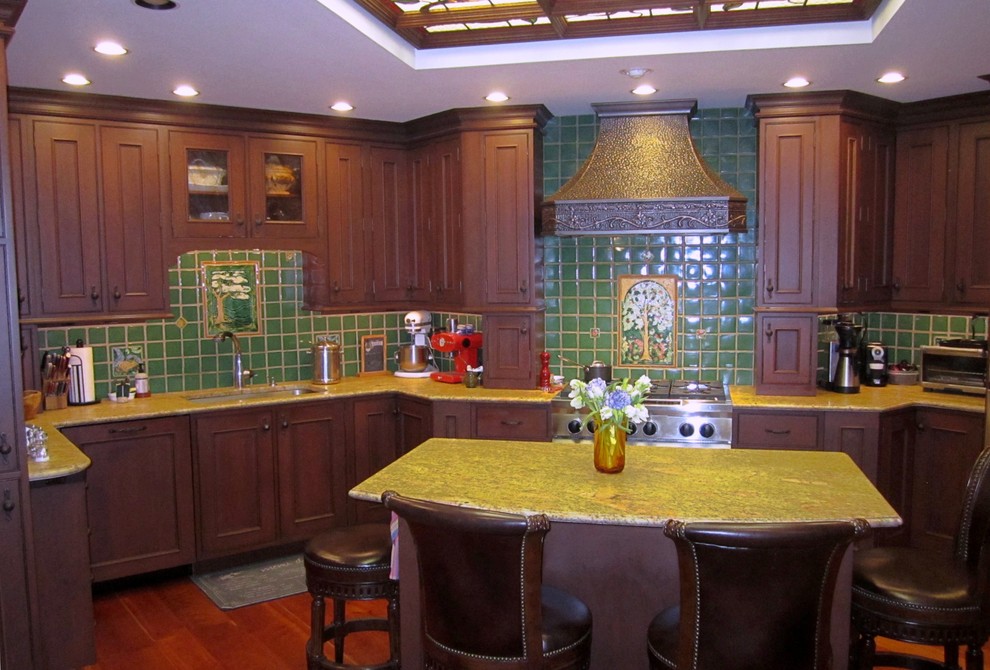 Photo of a large traditional u-shaped eat-in kitchen in Other with a single-bowl sink, beaded inset cabinets, dark wood cabinets, marble benchtops, green splashback, ceramic splashback, stainless steel appliances, dark hardwood floors, with island, brown floor and yellow benchtop.
