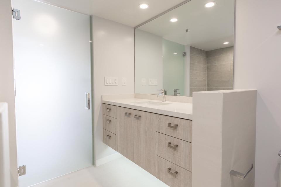 Photo of a mid-sized transitional master bathroom in Los Angeles with flat-panel cabinets, light wood cabinets, an alcove shower, a one-piece toilet, beige tile, porcelain tile, white walls, an undermount sink, beige floor and a hinged shower door.