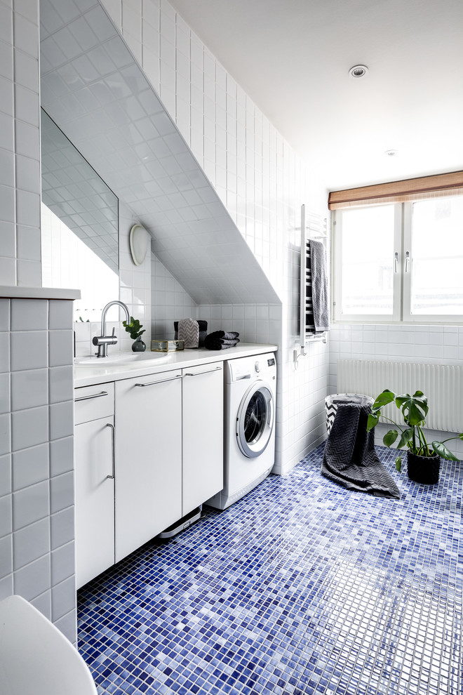 Mid-sized scandinavian bathroom in Stockholm with flat-panel cabinets, white cabinets, white tile, mosaic tile floors, blue floor and white benchtops.