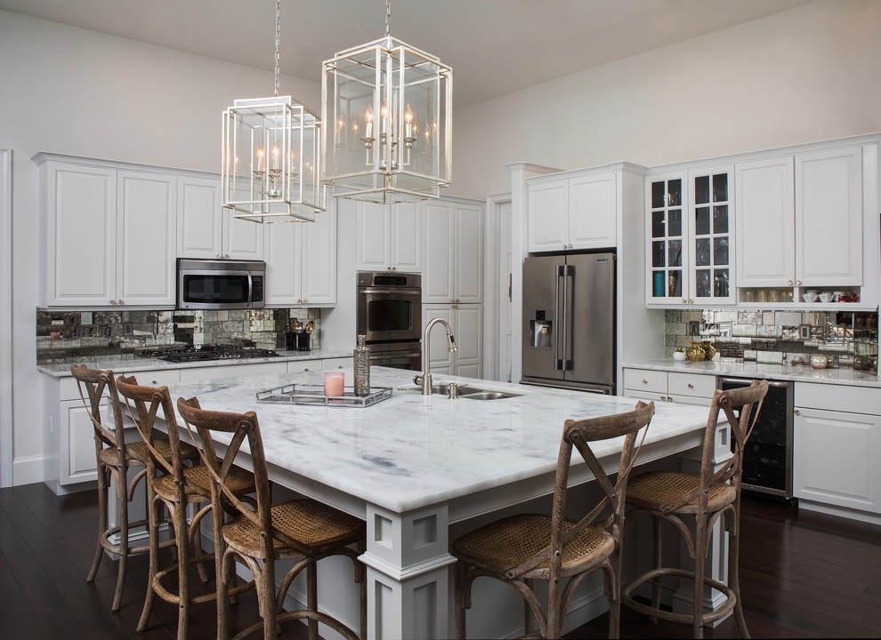This is an example of a large eclectic l-shaped open plan kitchen in Miami with raised-panel cabinets, white cabinets, quartz benchtops, metallic splashback, glass tile splashback, stainless steel appliances and with island.