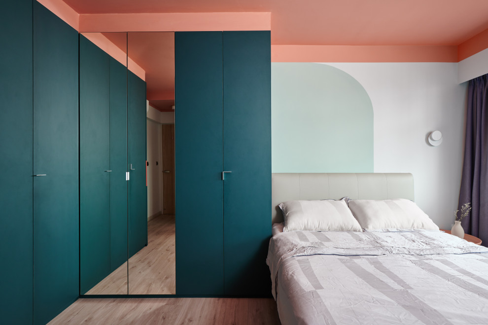 На фото: спальня в современном стиле с разноцветными стенами, паркетным полом среднего тона и коричневым полом с