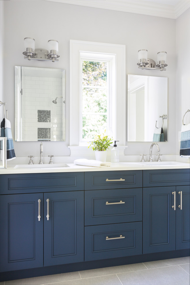 Design ideas for a large transitional 3/4 bathroom in Boston with blue cabinets, an alcove shower, grey walls, porcelain floors, an undermount sink, engineered quartz benchtops, grey floor, a hinged shower door, white benchtops and recessed-panel cabinets.