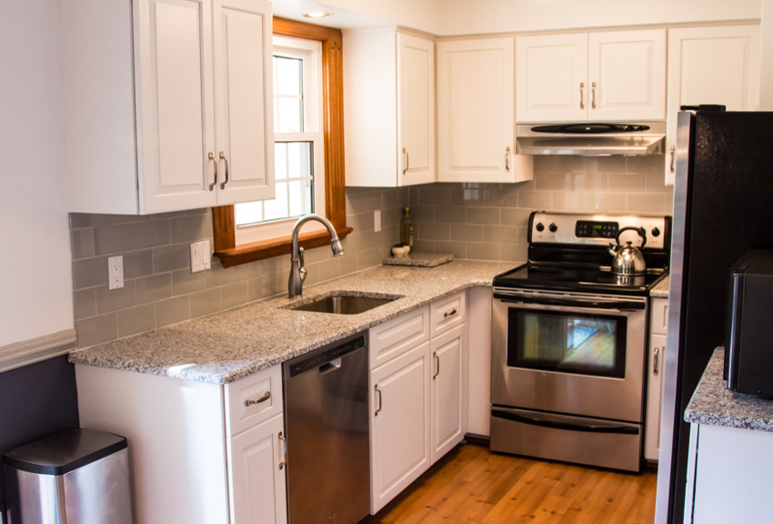 Example of a small transitional u-shaped light wood floor kitchen design in Baltimore with an undermount sink, raised-panel cabinets, white cabinets and no island