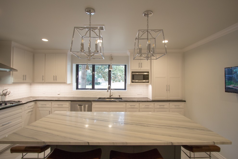 Example of a mid-sized transitional l-shaped porcelain tile and gray floor enclosed kitchen design in Dallas with a single-bowl sink, shaker cabinets, white cabinets, quartzite countertops, white backsplash, subway tile backsplash, stainless steel appliances and an island