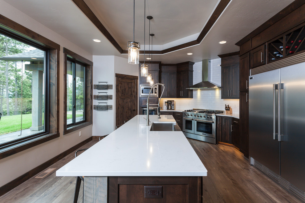 Kitchen - rustic kitchen idea with a farmhouse sink, white backsplash, ceramic backsplash, stainless steel appliances and an island